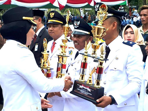 Ir. Hj. Tatong Bara Memberikan Piala Penghargaan Lomba Kebersihan Tingkat Kecamatan